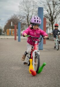 Kind fährt Kegeln mit Rad um